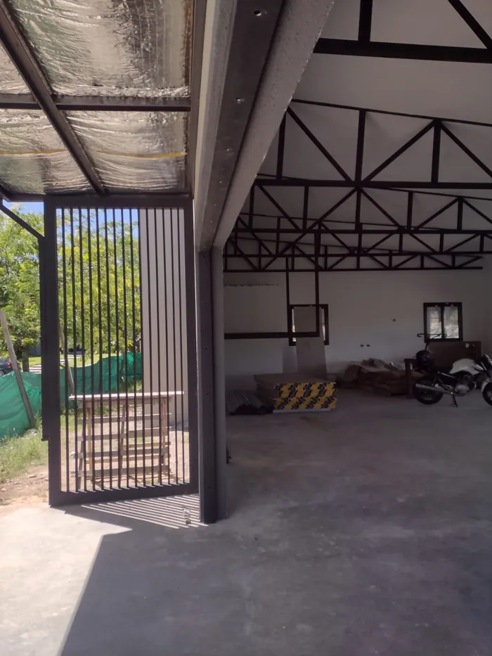 Interior en obra con la estructura metálica de cabreadas a la vista